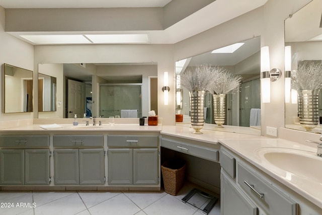 bathroom with tile patterned floors, a skylight, vanity, and an enclosed shower