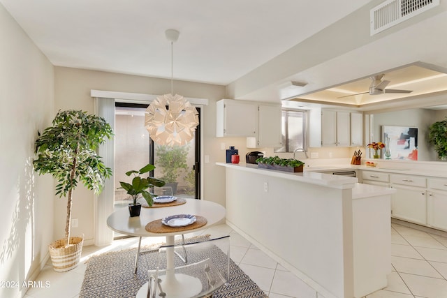 kitchen featuring kitchen peninsula, pendant lighting, white cabinetry, and plenty of natural light