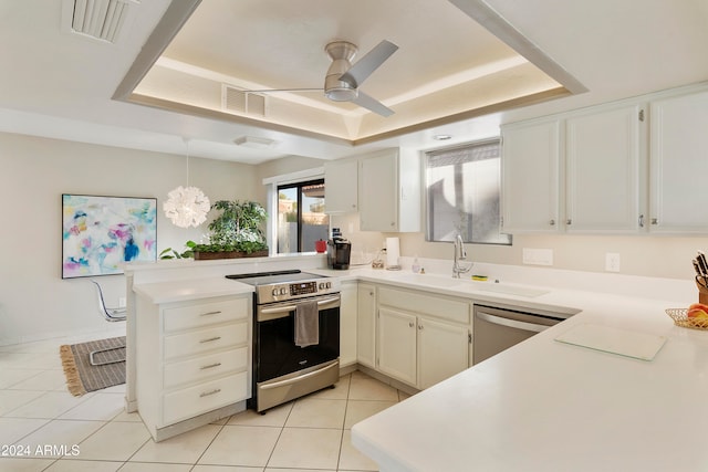 kitchen with sink, kitchen peninsula, hanging light fixtures, white cabinetry, and stainless steel appliances