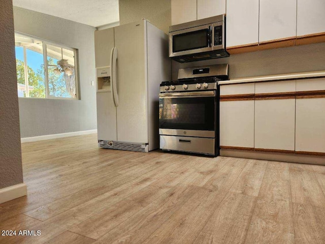 kitchen with light wood-type flooring, white cabinetry, and appliances with stainless steel finishes