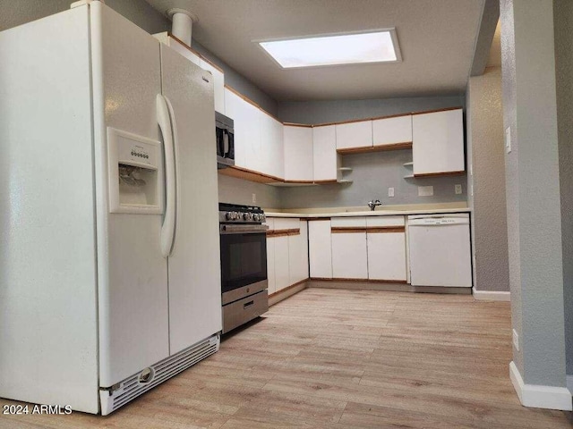 kitchen with sink, stainless steel appliances, light hardwood / wood-style floors, vaulted ceiling, and white cabinets