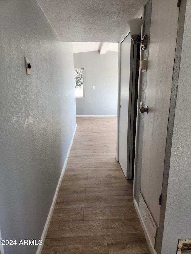 hall featuring a textured ceiling and light wood-type flooring