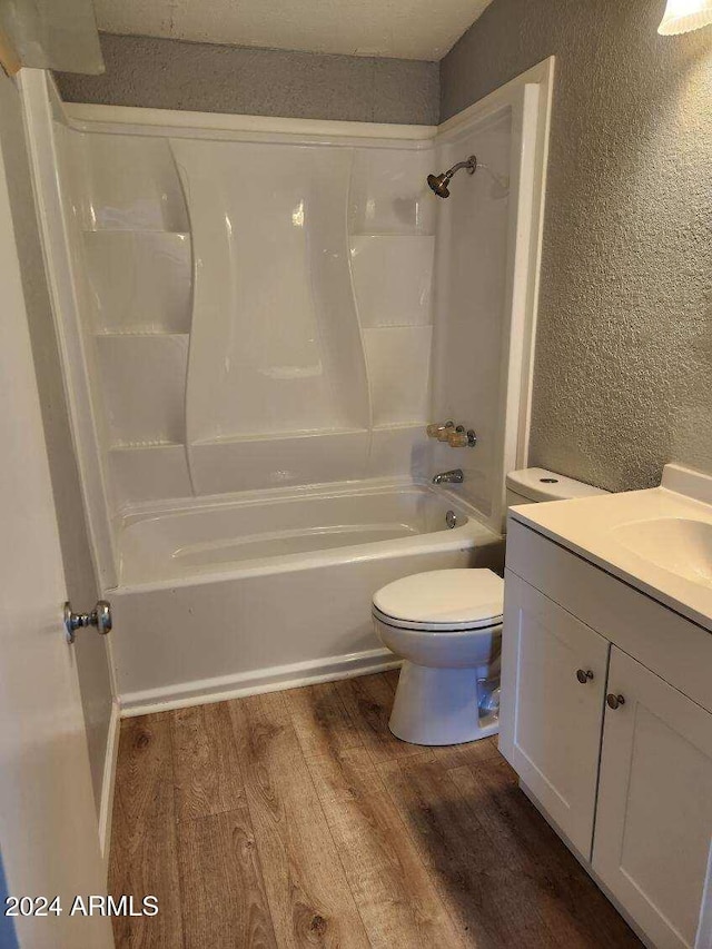 full bathroom with shower / bathing tub combination, wood-type flooring, vanity, and toilet