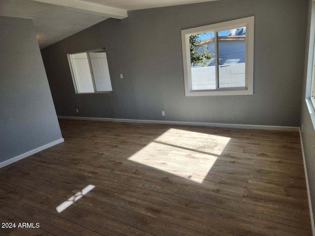 empty room with lofted ceiling with beams and dark wood-type flooring