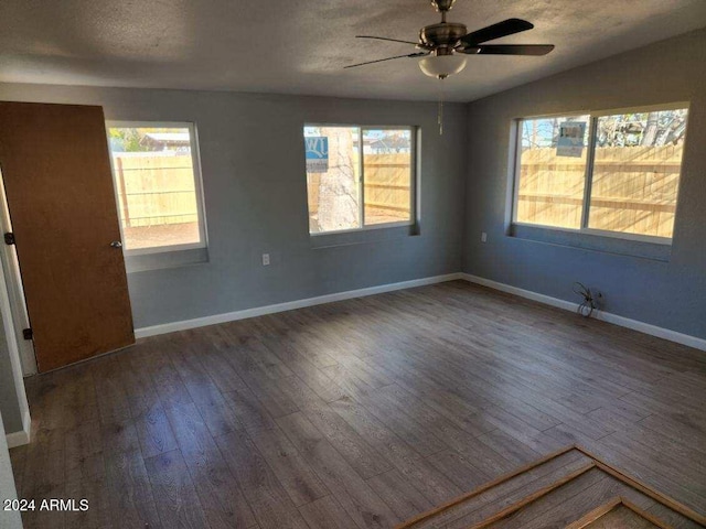 spare room with plenty of natural light, a textured ceiling, and hardwood / wood-style flooring