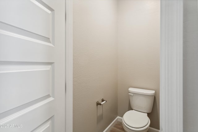 5815 E Covey Ln, Phoenix, AZ 85054 - bathroom with toilet, baseboards, and wood finished floors