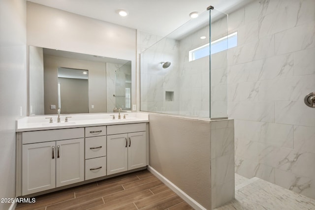 5815 E Covey Ln, Phoenix, AZ 85054 - full bathroom featuring double vanity, a walk in shower, wood finish floors, and baseboards