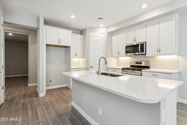 5815 E Covey Ln, Phoenix, AZ 85054 - kitchen with stainless steel appliances, a sink, baseboards, decorative backsplash, and recessed lighting