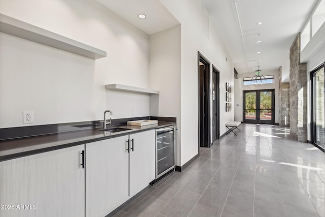 5815 E Covey Ln, Phoenix, AZ 85054 - kitchen with wine cooler, a sink, dark countertops, open shelves, and white cabinets