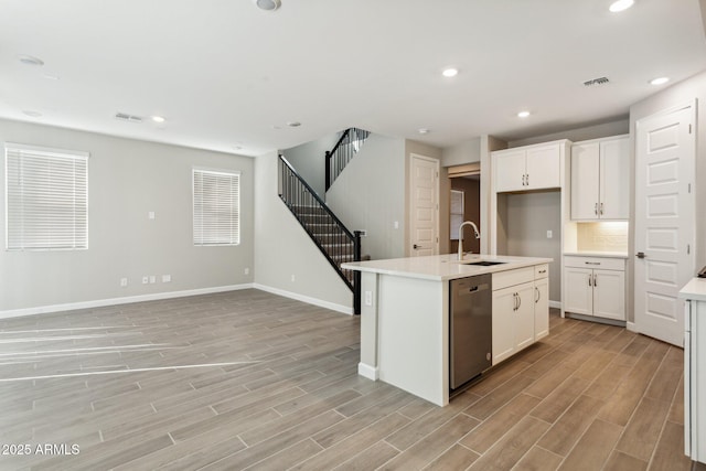 5815 E Covey Ln, Phoenix, AZ 85054 - kitchen with stainless steel dishwasher, a sink, light wood-style floors, baseboards, and light countertops