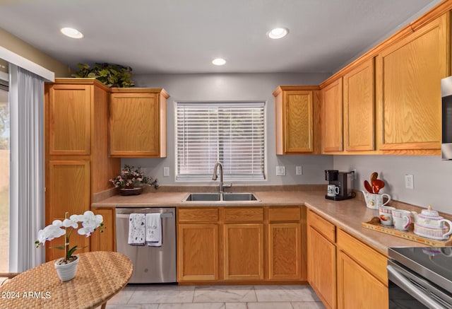 kitchen featuring a wealth of natural light, dishwasher, and sink