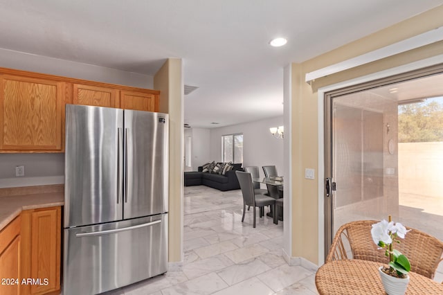 kitchen featuring stainless steel fridge and a chandelier