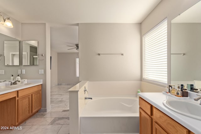 bathroom with a tub to relax in, vanity, and ceiling fan