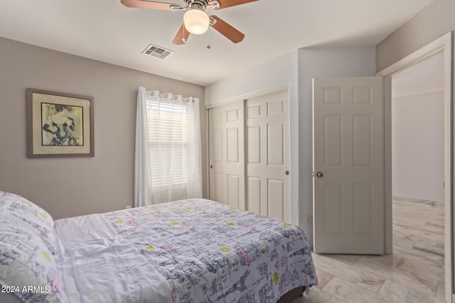 bedroom with ceiling fan and a closet