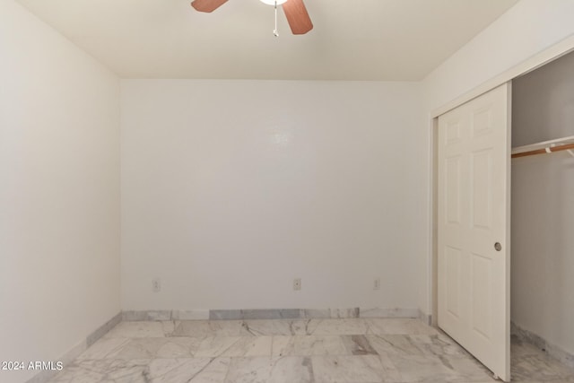 unfurnished bedroom featuring ceiling fan and a closet