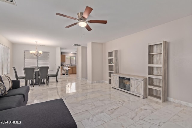 living room featuring ceiling fan with notable chandelier and built in features