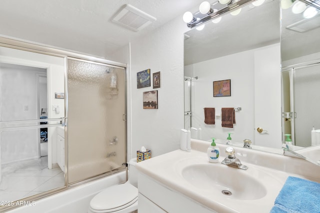 full bathroom with enclosed tub / shower combo, vanity, and toilet