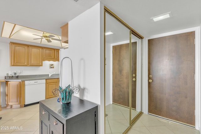 kitchen with light tile patterned flooring, sink, ceiling fan, and white dishwasher