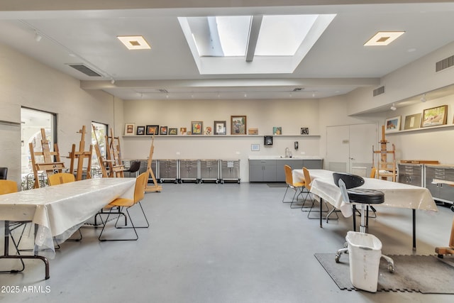 dining area featuring concrete floors and a skylight