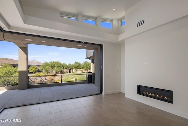 unfurnished living room with a mountain view and light tile patterned flooring