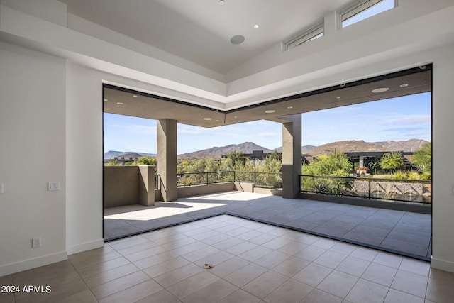 doorway to outside with tile patterned floors, a mountain view, and lofted ceiling