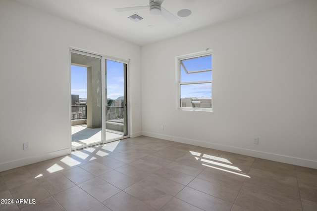 tiled spare room featuring ceiling fan