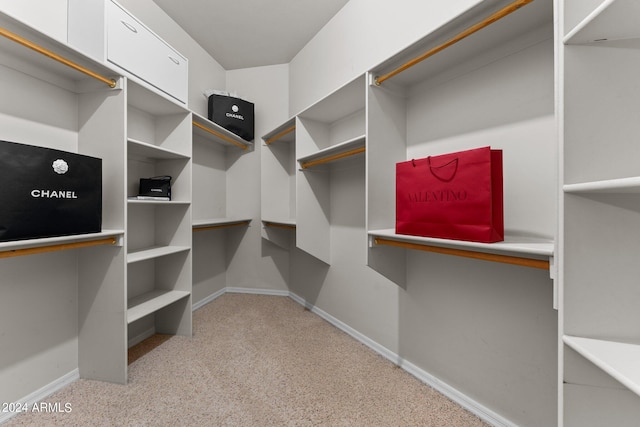 walk in closet featuring light colored carpet