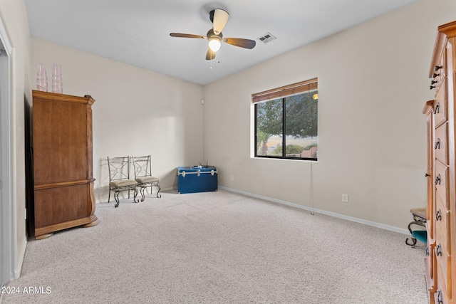 interior space with ceiling fan and light colored carpet