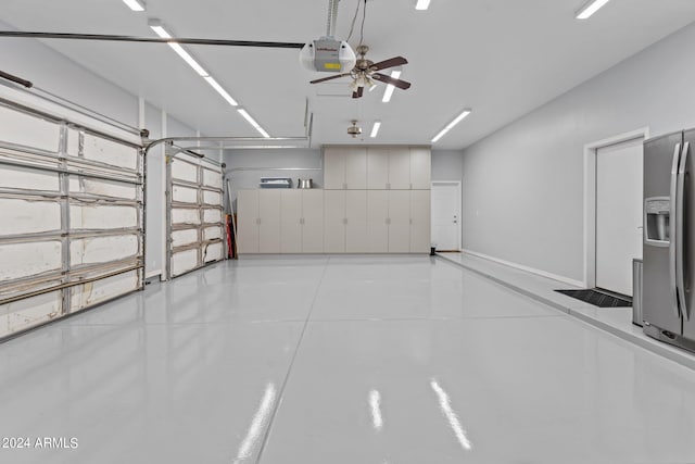 garage featuring a garage door opener and stainless steel refrigerator with ice dispenser