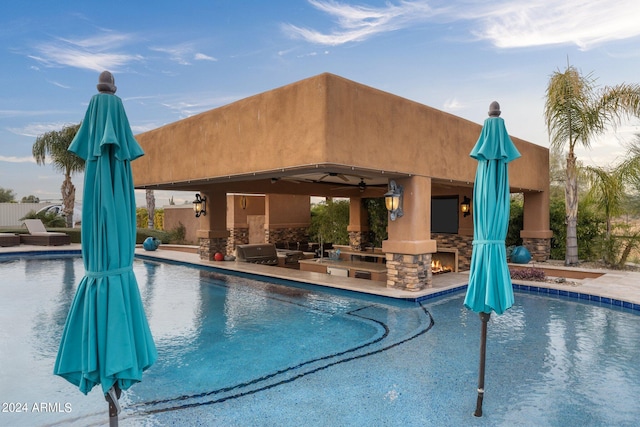 view of swimming pool featuring ceiling fan, a gazebo, a patio, and exterior kitchen