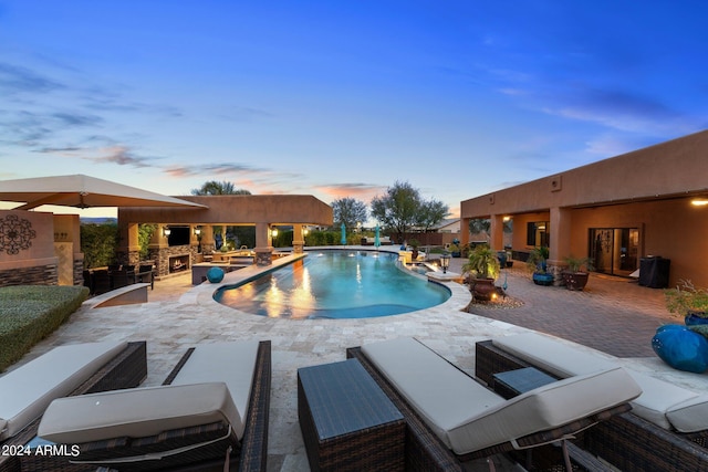 pool at dusk featuring a patio area