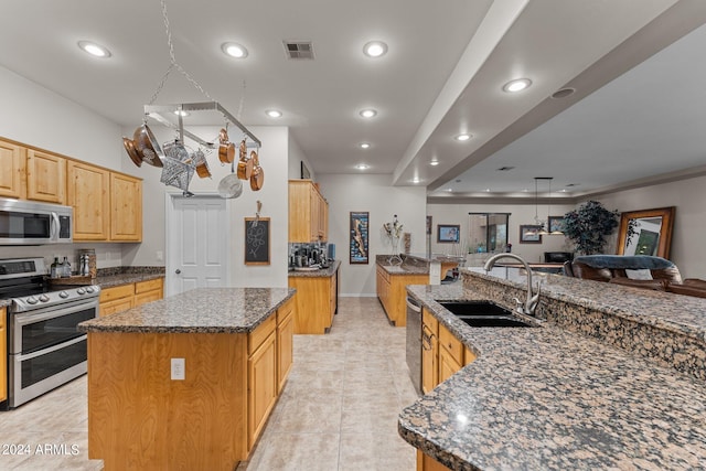 kitchen with light tile patterned flooring, a large island, sink, and stainless steel appliances