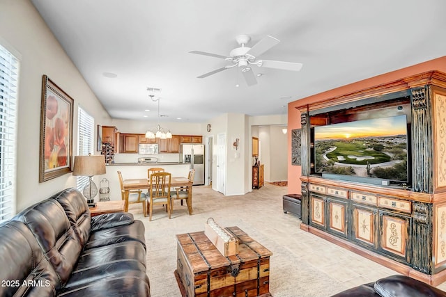 living area with light tile patterned floors, ceiling fan with notable chandelier, and visible vents