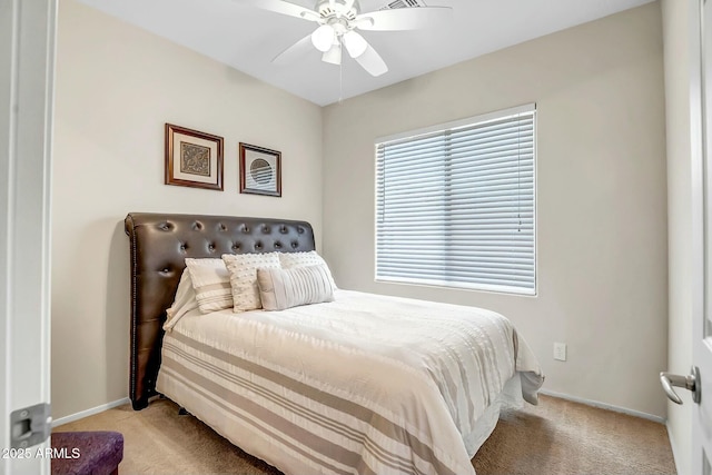 bedroom featuring light colored carpet, a ceiling fan, and baseboards