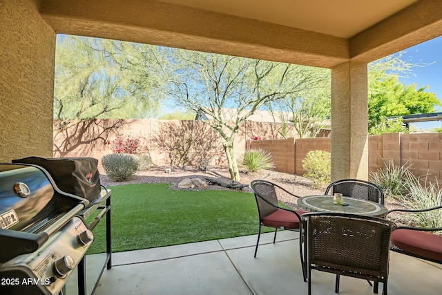 view of patio with grilling area, outdoor dining space, and a fenced backyard