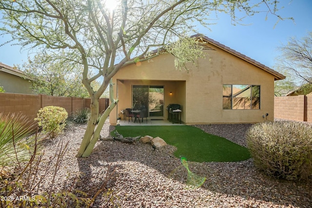 back of property featuring a patio area, stucco siding, a tile roof, and a fenced backyard