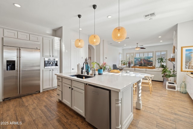 3917 E Patrick Ln, Phoenix, AZ 85050 - kitchen with appliances with stainless steel finishes, dark wood-style floors, recessed lighting, light countertops, and pendant lighting