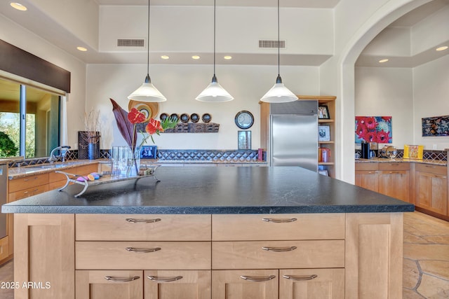 kitchen featuring pendant lighting, light brown cabinets, and built in refrigerator