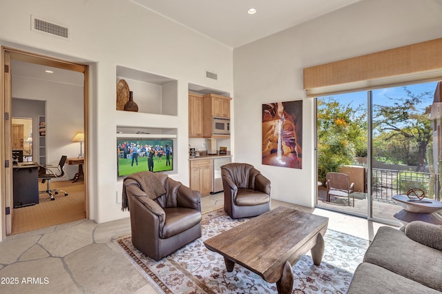 living room featuring a towering ceiling and built in features