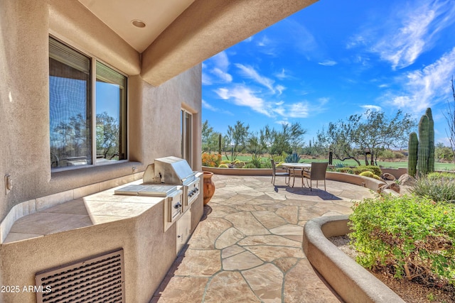 view of patio with area for grilling and a grill