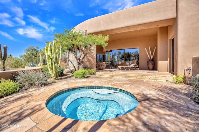 view of swimming pool featuring an in ground hot tub and a patio