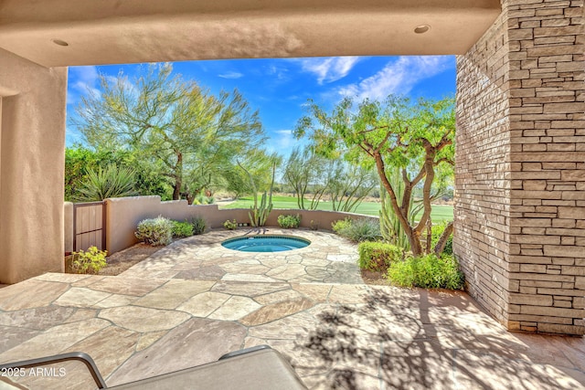 view of patio / terrace with an in ground hot tub