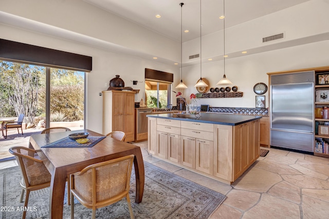 kitchen with appliances with stainless steel finishes, a healthy amount of sunlight, pendant lighting, and light brown cabinets