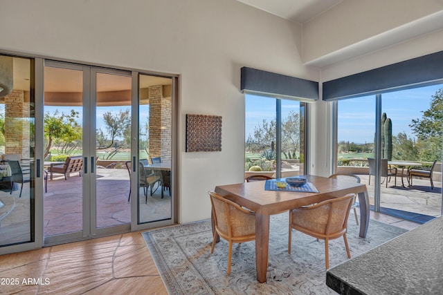 dining space featuring a towering ceiling and french doors