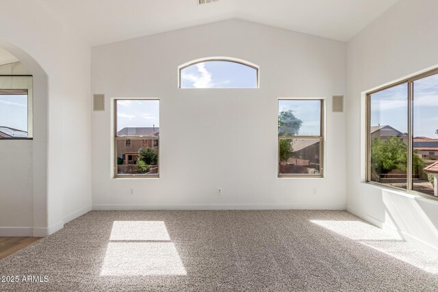 2112 S 160th Dr, Goodyear, AZ 85338 - empty room featuring plenty of natural light, carpet flooring, arched walkways, and lofted ceiling