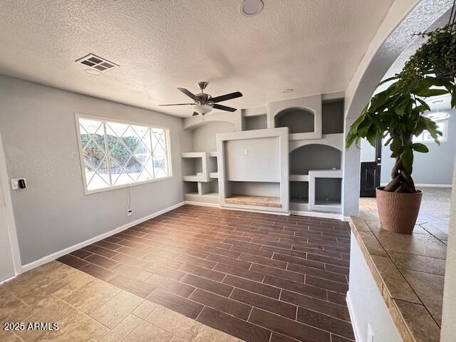 unfurnished living room featuring a textured ceiling and ceiling fan