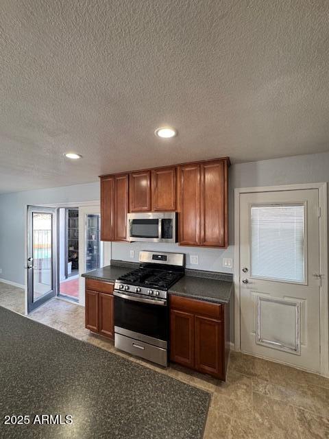 kitchen with a textured ceiling and stainless steel appliances