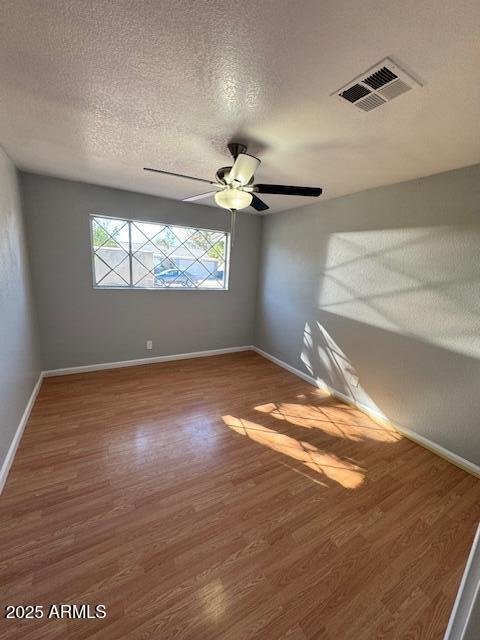 unfurnished room featuring a textured ceiling, ceiling fan, and hardwood / wood-style floors