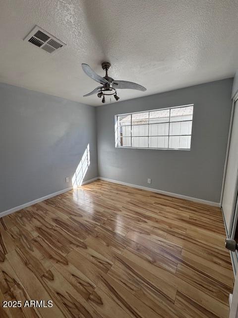 unfurnished room featuring ceiling fan, plenty of natural light, and hardwood / wood-style floors