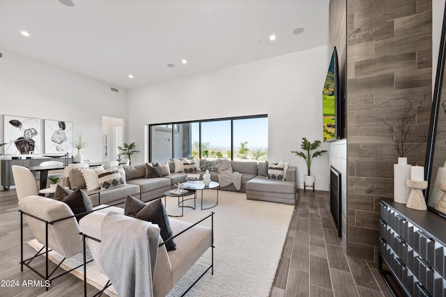 living room with a towering ceiling and a fireplace